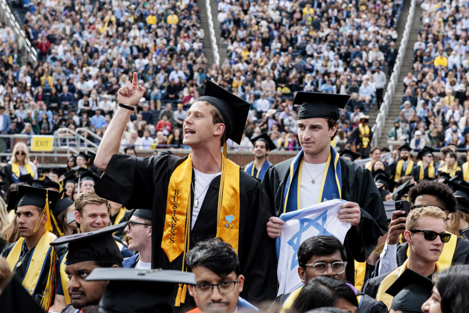 Graduates sporting Israeli flags and pins shout at Pro-Palestinian protesters as they demonstrate during the University of Michigan's Spring 2024 Commencement Ceremony at Michigan Stadium in Ann Arbor, Mich., on Saturday, May 4, 2024.( Jacob Hamilton/Ann Arbor News via AP)
