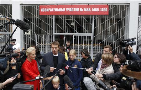 Russian opposition leader Alexei Navalny (C), accompanied by his wife Yulia and children Dasha and Zakhar, talks to the media outside a polling station in Moscow September 8, 2013. REUTERS/Maxim Shemetov