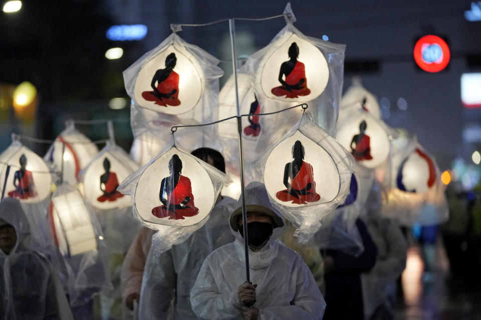 A Buddhist carries lanterns and walk in a parade during the Lotus Lantern Festival, ahead of the birthday of Buddha at Dongguk University in Seoul, South Korea, Saturday, May 11, 2024. (AP Photo/Ahn Young-joon)