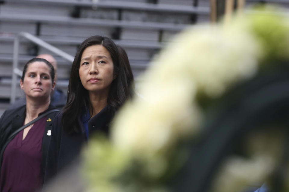 Boston Mayor Michelle Wu walks past a wreath during a gathering near memorials for victims of the 2013 Boston Marathon bombing, Saturday April 15, 2023, in Boston. (AP Photo/Reba Saldanha)