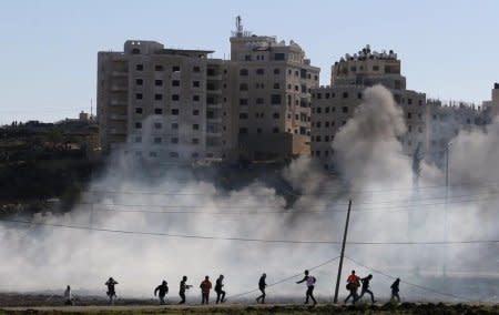 Palestinian protesters run away from tear gas fired by Israeli troops during clashes near the Jewish settlement of Bet El, near the West Bank city of Ramallah November 13, 2015. REUTERS/Mohamad Torokman