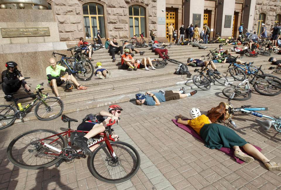 Heute mahnt ein zerstörtes Militärfahrzeug vor dem Rathaus, auf dem Banner wird Unterstützung für die Verteidiger von Mariupol gefordert. Wie aus einer anderen Zeit wirken die Radfahrer, die mit einem Liegeprotest für mehr Radwege vor dem Rathaus demonstrierten. (Bild oben: Zinchenko/Global Images Ukraine via Getty Images / unten: Pavlo Gonchar/SOPA Images/LightRocket via Getty Images)