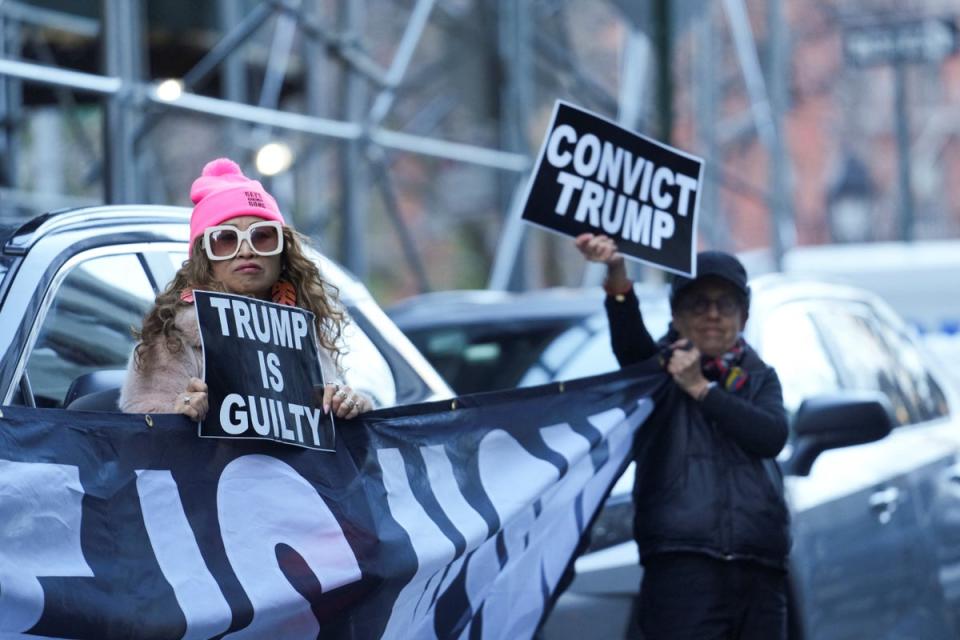 Anti-Trump protesters hold signs outside Manhattan Criminal Court after Donald Trump’s indictment (REUTERS)