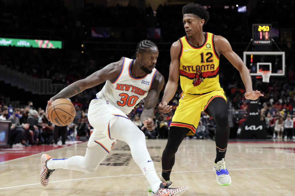 Atlanta Hawks forward De'Andre Hunter (12) cuts off the lane as New York Knicks forward Julius Randle (30) drives to the basket during the second half of an NBA basketball game Saturday, Jan. 15, 2022, in Atlanta. (AP Photo/Butch Dill)