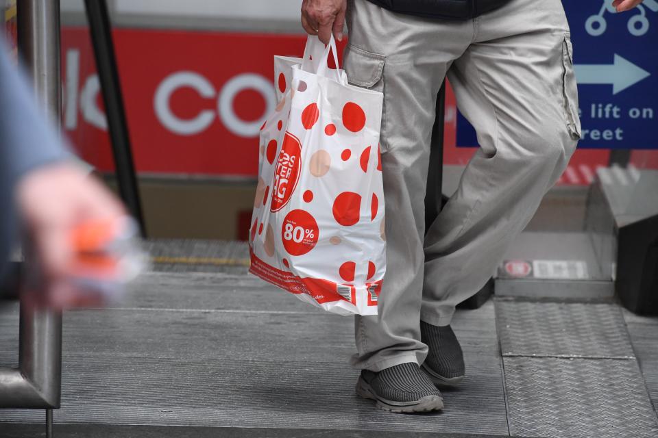 A shopper is seen carrying a reusable plastic bag at a Coles Sydney CBD store.