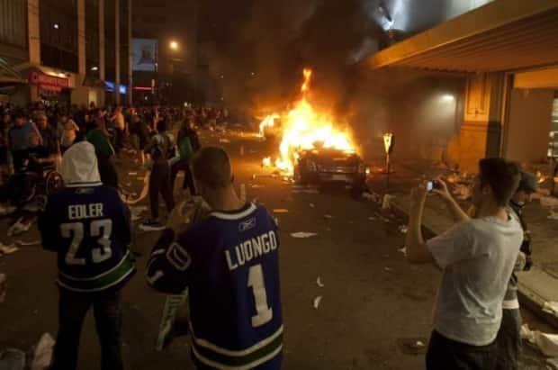 People look on amid rioting in downtown Vancouver following the Vancouver Canucks 4-0 loss to the Boston Bruins in Game 7 of the Stanley Cup final in 2011.  (Ryan Remiorz/The Canadian Press) ( - image credit)