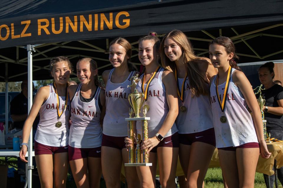 The Oak Hall girls varsity team holds their first-place trophy during the Bobcat Classic cross country meet at Santa Fe College in Gainesville, on Sept. 10, 2022.