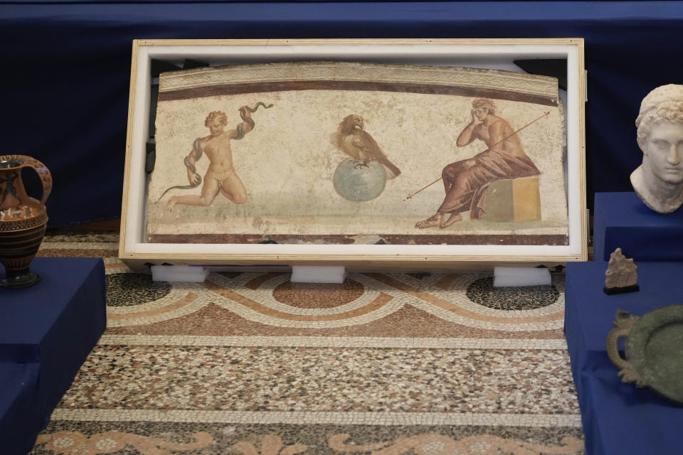 A Pompeiian style fresco from Herculaneum titled "Young Hercules and the snake", dated to the I second A.C., is seen on display among other archaeological artifacts stolen from Italy and sold in the US by international art traffickers, during a press conference in Rome, Monday, Jan. 23, 2023. 60 stolen artifacts, for an estimated total value of 20 million dollars, have been recovered in private collections in the US and returned to Italy after a joint investigation by Italian Carabinieri police and the New York County District Attorney's Office. (AP Photo/Andrew Medichini)