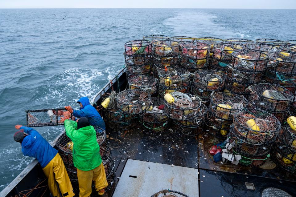 Anthony Abell, left, Grant Elvehjem, center, and Lyle Ashouwak, right, drop crab pots from the Fishing Vessel Insatiable. As ocean temperatures rise, fishers everywhere must adapt to harvesting different species. Garrett Kavanaugh, captain of the Fishing Vessel Insatiable out of the port of Kodiak Island, has made large investments in equipment, fuel, and labor, betting on Dungeness crabs as the future of his Alaskan fishing business.