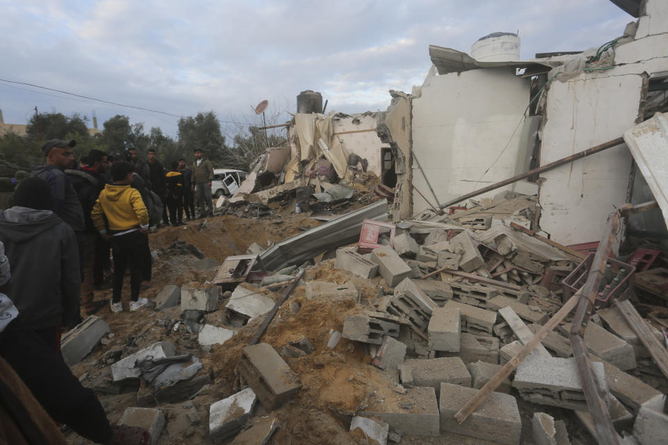 Palestinians look at a residential house destroyed in an Israeli strike in Rafah, Gaza Strip, Monday, Feb. 5, 2024. (AP Photo/Hatem Ali)