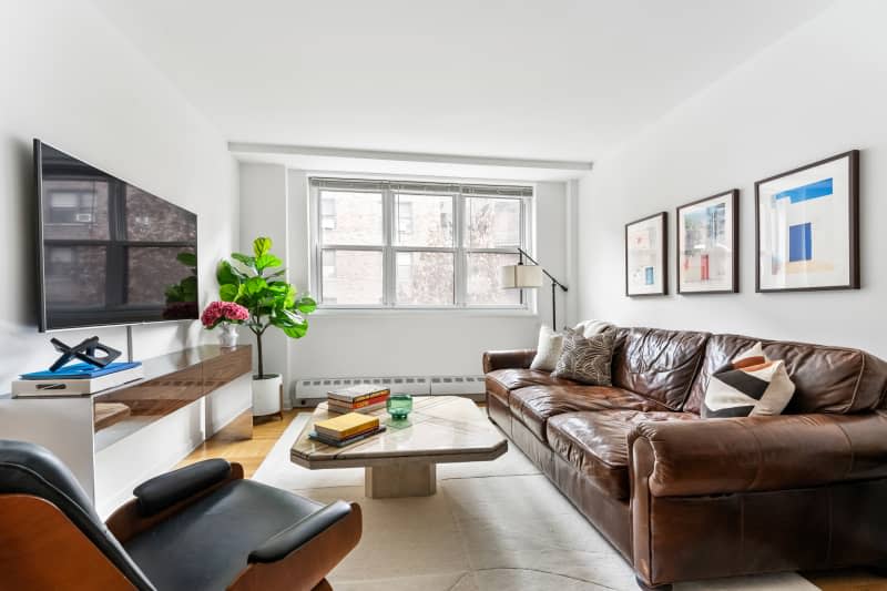 White living room with brown leather sofa