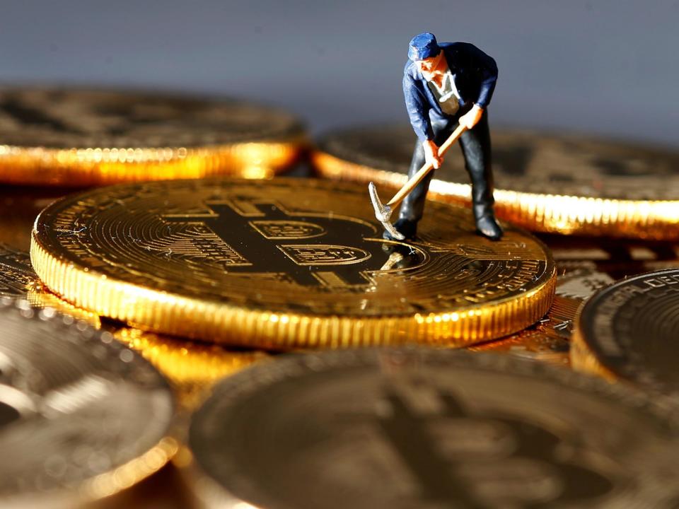 A small toy figure is seen on representations of the Bitcoin virtual currency in this illustration picture, December 26, 2017: REUTERS/Dado Ruvic