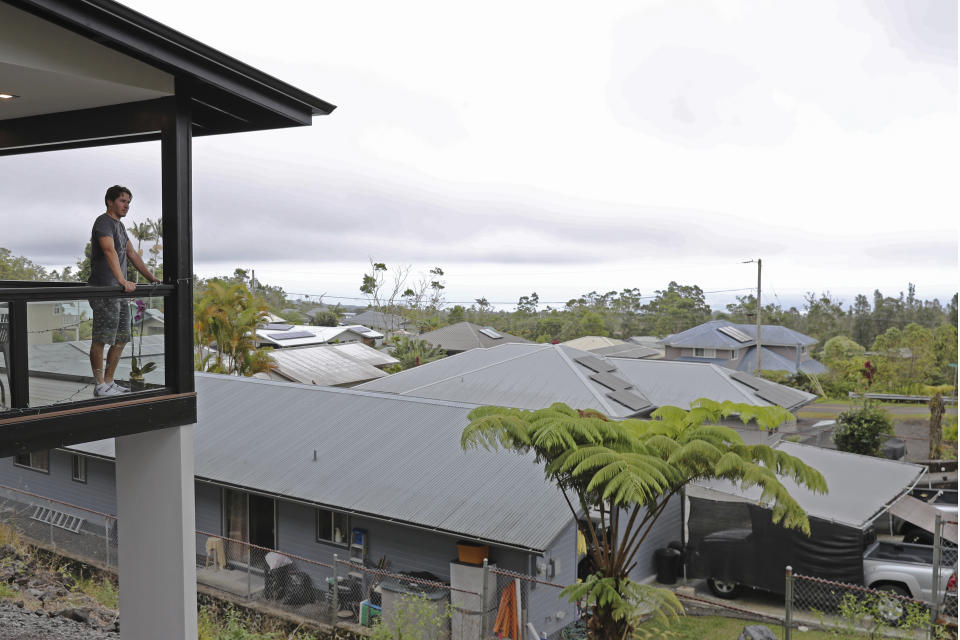 Tom Schneider over looks his neighborhood from his balcony, Tuesday, Nov. 29, 2022, in Hilo, Hawaii. (AP Photo/Marco Garcia)