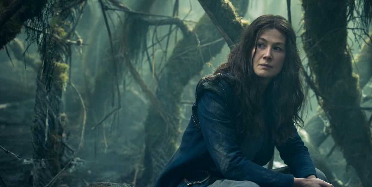 rosamund pike sitting in forest in wheel of time