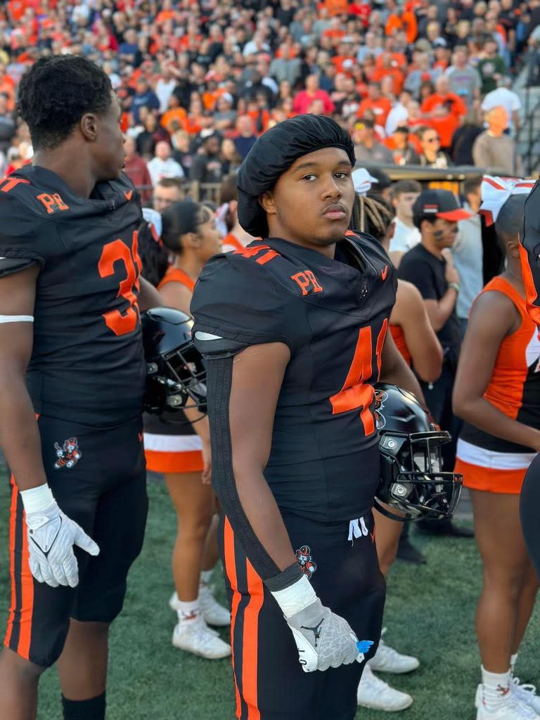 Massillon senior Shon Robinson (right) stands on the sidelines ahead of a 2023 home game.