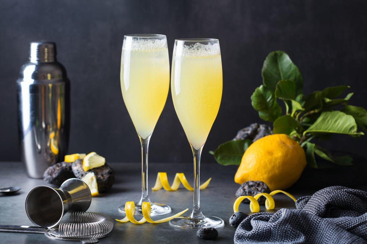 French 75 cocktail with lemon hard seltzer instead of champagne. Summer refreshing beverage, drink on a table with bartenders accessories for mixology