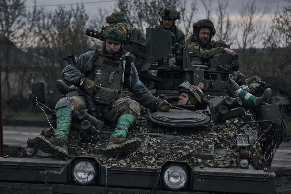 Ukrainian soldiers ride atop an APC on the frontline in Bakhmut, Donetsk region, Ukraine, Saturday, April 8, 2023. (AP Photo/Libkos)