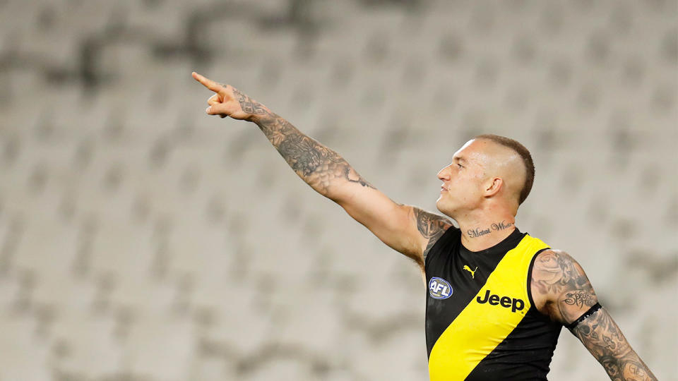 Dustin Martin celebrates and points in front of no crowd during the 2020 AFL Round 01 match.