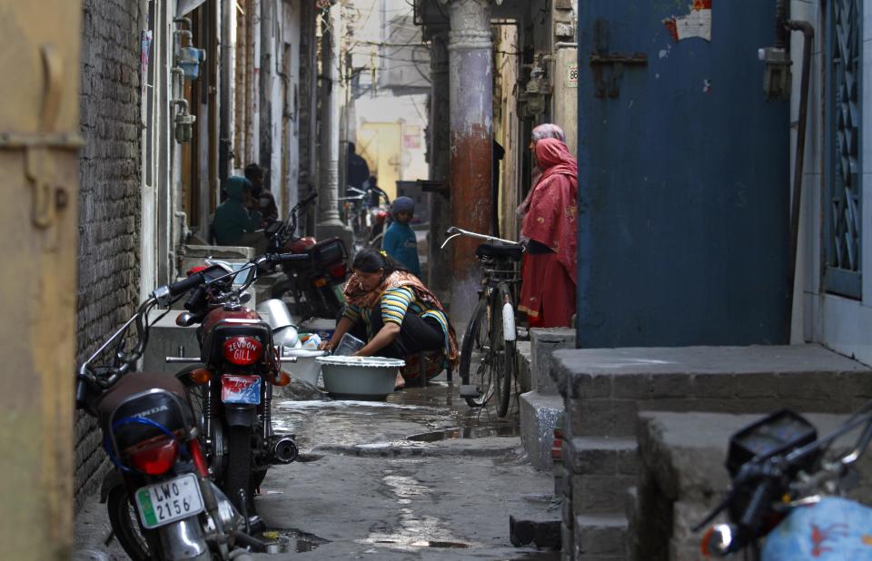 In this Saturday, Jan. 11, 2014 photo, a Pakistani Christian woman washes clothes in a narrow alley in a Christian neighborhood, which was torched last March by radical Muslim's mobs in Lahore, Pakistan. Pakistan’s blasphemy law has become a potent weapon in the arsenal of Muslim extremists, who use it against adherents of minority religions. (AP Photo/Anjum Naveed)