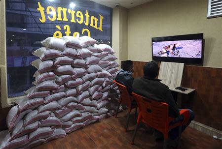 Residents play computer games at an internet cafe where sandbags were piled as protection from future explosions at a stronghold of the Shi'ite group Hezbollah in the southern suburbs of the Lebanese capital Beirut January 28, 2014. REUTERS/Hasan Shaaban