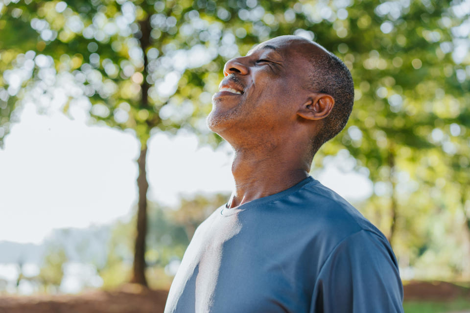 A man breathing fresh air while in nature (Photo: Getty Images)