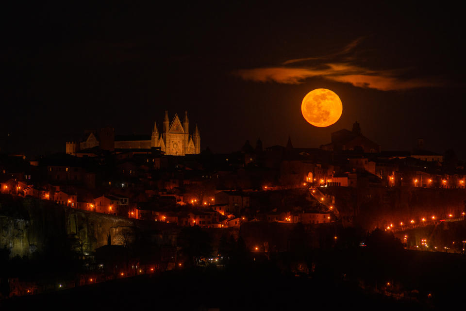 a bright full moon in the sky over a city