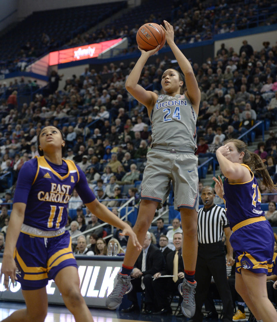 Connecticut's Napheesa Collier, center, shoots over East Carolina's Raven Johnson, left, in the first half of an NCAA college basketball game, Wednesday, Jan. 4, 2017, in Hartford, Conn. (AP Photo/Jessica Hill)