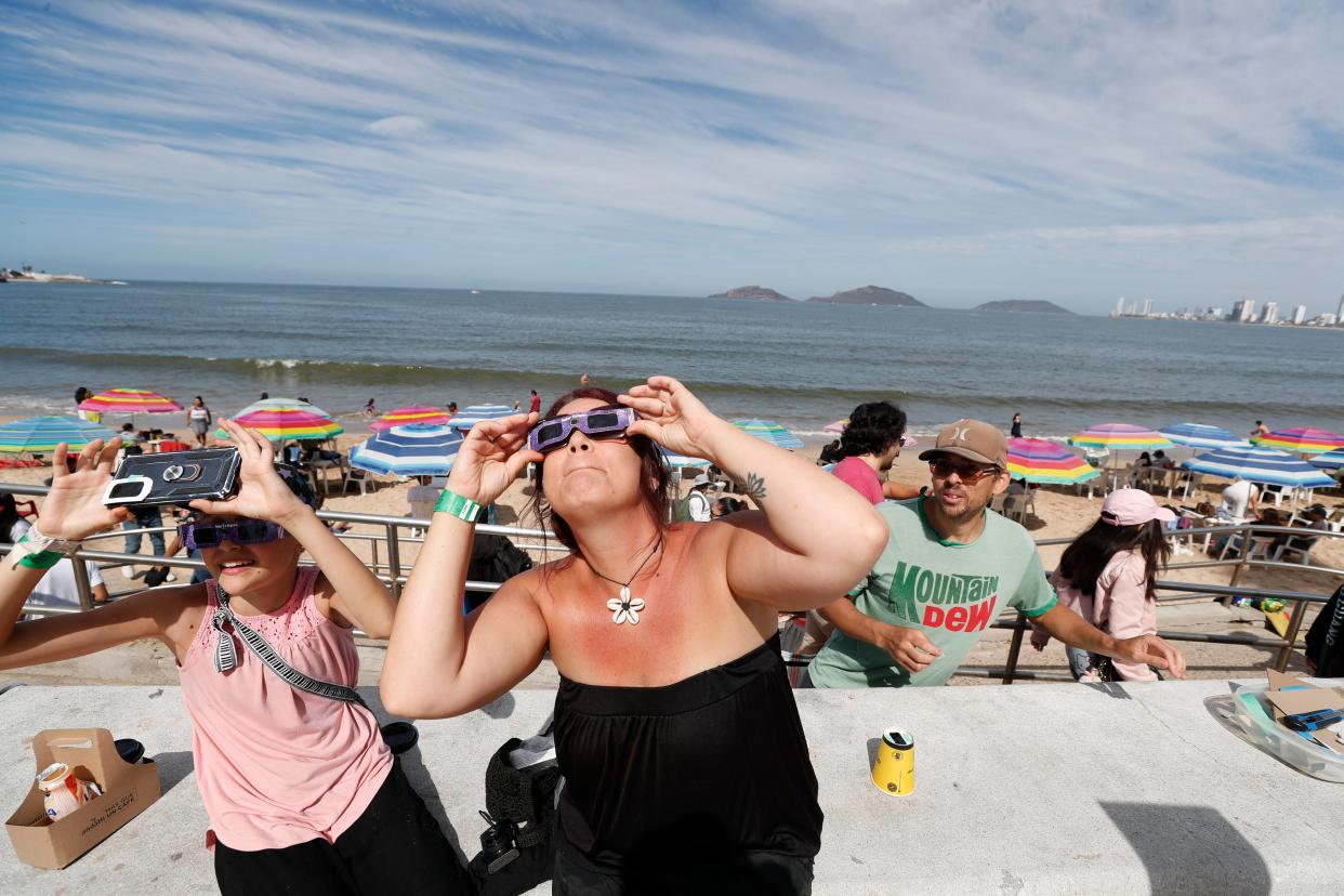 Samantha Jack and her daughter, Olivia Mykytuk, check out their eclipse glasses in preparation for the arrival of the solar eclipse in North America in the coastal city of Mazatlan, Sinaloa on April 8, 2024. A full solar eclipse will be visible in Mazatlan first before it moves north through Mexica and then the state of Texas.