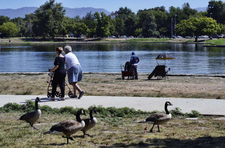 An elderly gentleman takes a morning stroll along Balboa Lake in Balboa Park in Los Angeles on Wednesday, July 12, 2023. (AP Photo/Richard Vogel)