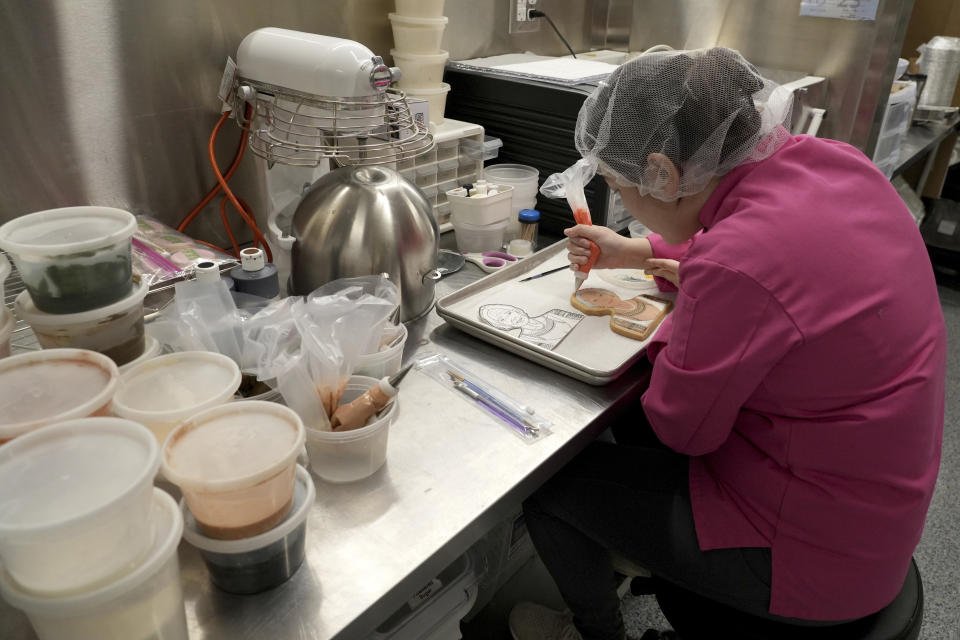 Jasmine Cho works on a cookie portrait of Filipina mambabatok tattoo artist Apo Whang-Od in Pittsburgh, Pa., Wednesday, May 3, 2023. Cho, a Korean American self-described “cookie activist,” has gained fans over the last several years for her finely detailed cookie mugs of famous and forgotten figures. (AP Photo/Matt Freed)