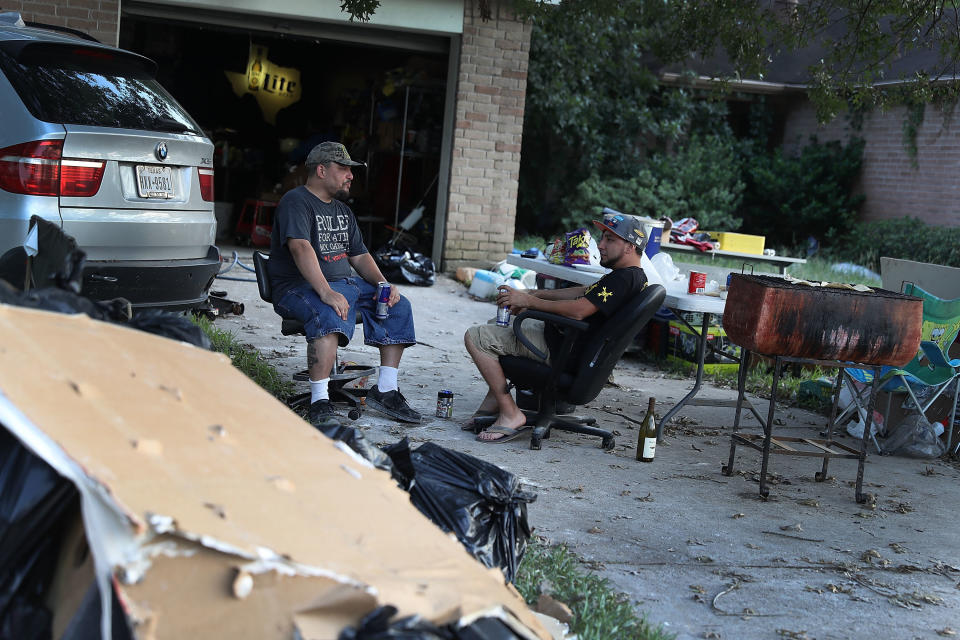 Artemio Tamez and Franco Tamez sit in front of Franco's house on Sept. 2 after spending the day cleaning it out&nbsp;after torrential rains in the wake of Hurricane Harvey caused widespread flooding throughout the Houston area.