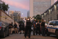 Police officers and detectives enter the crime scene area where a 9-year-old boy was fatally shot, Friday, July 31, 2020, in Chicago. A suspect has been arrested in the fatal shooting of Janari Ricks and police hope to secure charges against him in the coming days, the city's police superintendent said Monday, Aug. 3, 2020. (John J. Kim/Chicago Tribune via AP)