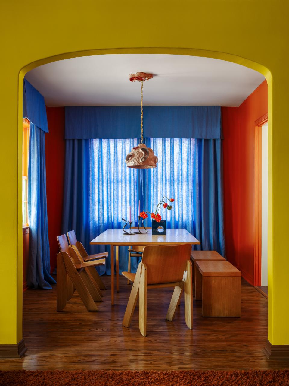 A mix of vintage and modern pieces play together in the dining room, like a still life framed by a gorgeous chartreuse arch.