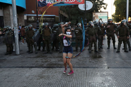 A Mapuche indigenous activist performs a dance near the government house during a protest demanding justice for Camilo Catrillanca, an indigenous Mapuche man who was shot in the head during a police operation, in Santiago, December 20, 2018. REUTERS/Ivan Alvarado