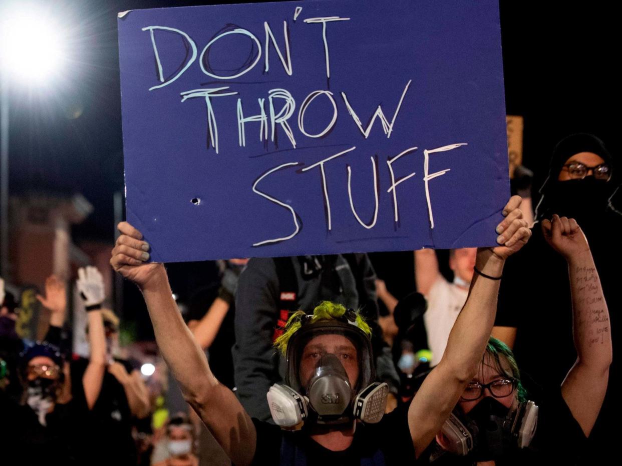 A demonstrator holds up a sign during a protest in Denver, Colorado, against violence: AFP via Getty Images