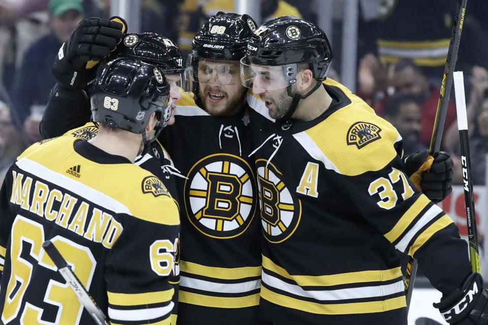 Boston Bruins right wing David Pastrnak celebrates his goal against the Columbus Blue Jackets with teammates Brad Marchand (63) and Patrice Bergeron (37) in the second period of an NHL hockey game, Thursday, Jan. 2, 2020, in Boston. (AP Photo/Elise Amendola)