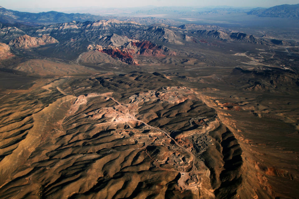 FILE - In this Oct. 11, 2016 photo, a gypsum mine owned by developer Jim Rhodes, who wants to develop housing on the site, is seen in the foreground while the Red Rock Canyon National Conservation Area is seen in the distance. Despite drought, cities in the U.S. West expect their populations to grow considerably in the coming decades. From Phoenix to Boise, officials are working to ensure they have the resources, infrastructure and housing supply to meet growth projections. In certain parts of the region, their efforts are constrained by the fact that sprawling metro areas are surrounded by land owned by the federal government. U.S. Sen. Catherine Cortez Masto wants to remedy the issue in Las Vegas by strengthening protections for some public lands while approving the sale of others to commercial and residential developers. (L.E. Baskow/Las Vegas Sun via AP, File)