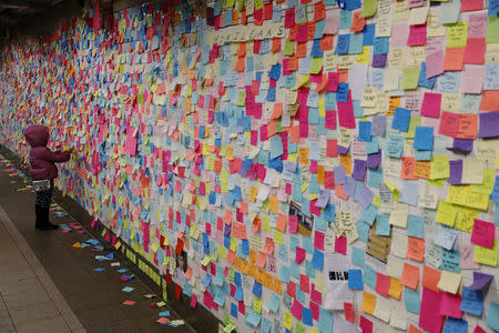 A young girl adds a message written on a sticky note to a display that was started in reaction to the election of President-elect Donald Trump in New York. REUTERS/Lucas Jackson