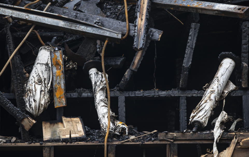 Scrolls from the synagogue that were burned by the fire hang out the back of the destroyed building on Sunday September 15, 2019. The fire that destroyed the historic synagogue doesn't appear to have been a hate crime, authorities said Sunday in discussing the arrest of a suspect. (Alex Kormann/Star Tribune via AP)