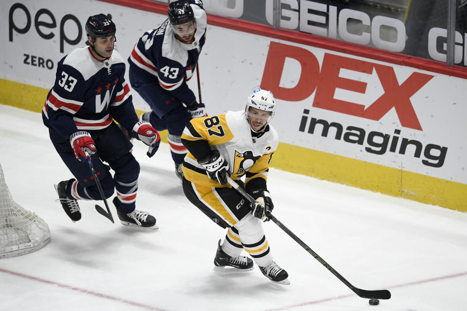 Pittsburgh Penguins center Sidney Crosby (87) skates with the puck past Washington Capitals defenseman Zdeno Chara (33) and right wing Tom Wilson (43) during the first period of an NHL hockey game Saturday, May 1, 2021, in Washington. (AP Photo/Nick Wass)