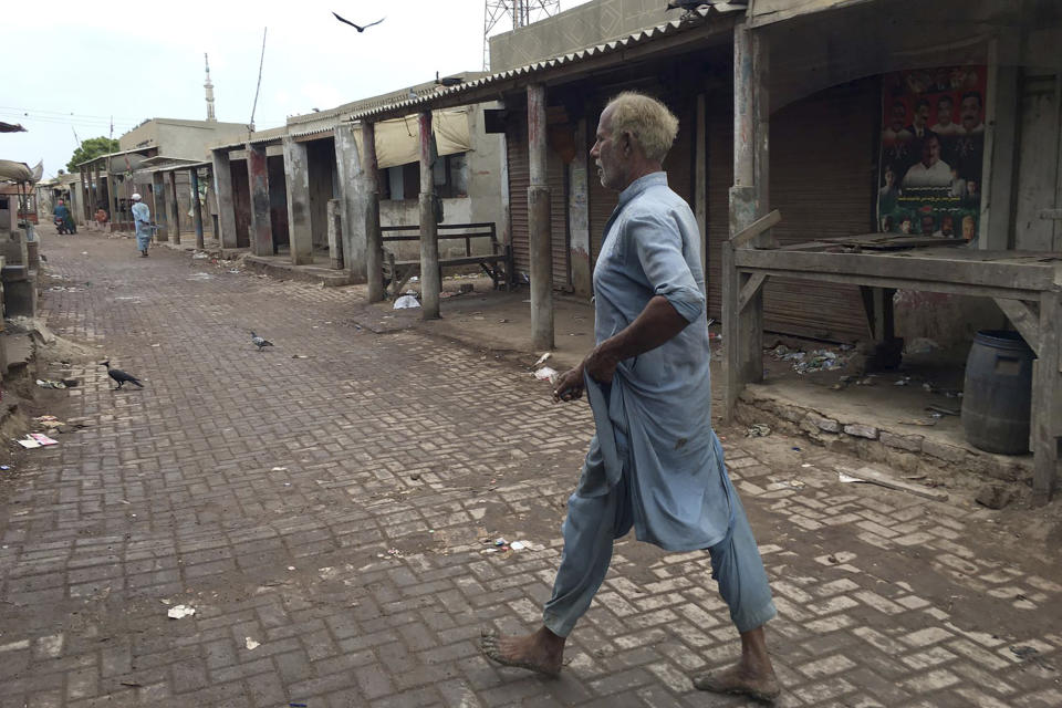 A local resident walks in an empty market after people evacuated due to Cyclone Biparjoy approaching, at a costal area Keti Bandar near Thatta, in Pakistan's Sindh province, Tuesday, June 13, 2023. Pakistan's army and civil authorities are planning to evacuate 80,000 people to safety along the country's southern coast, and thousands in neighboring India sought shelter ahead of Cyclone Biparjoy, officials said. (AP Photo/Muhammad Hamza)