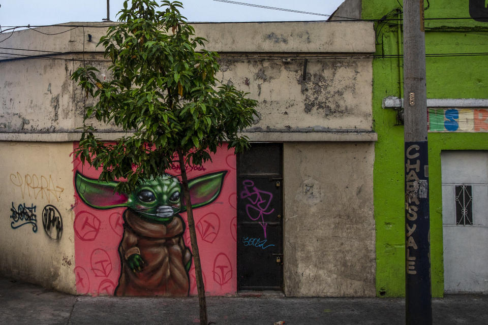 A graffiti of "The Child," dubbed "Baby Yoda" character, wearing a face mask, is painted on a wall in Guatemala City, Monday, April 6, 2020. (AP Photo/Moises Castillo)