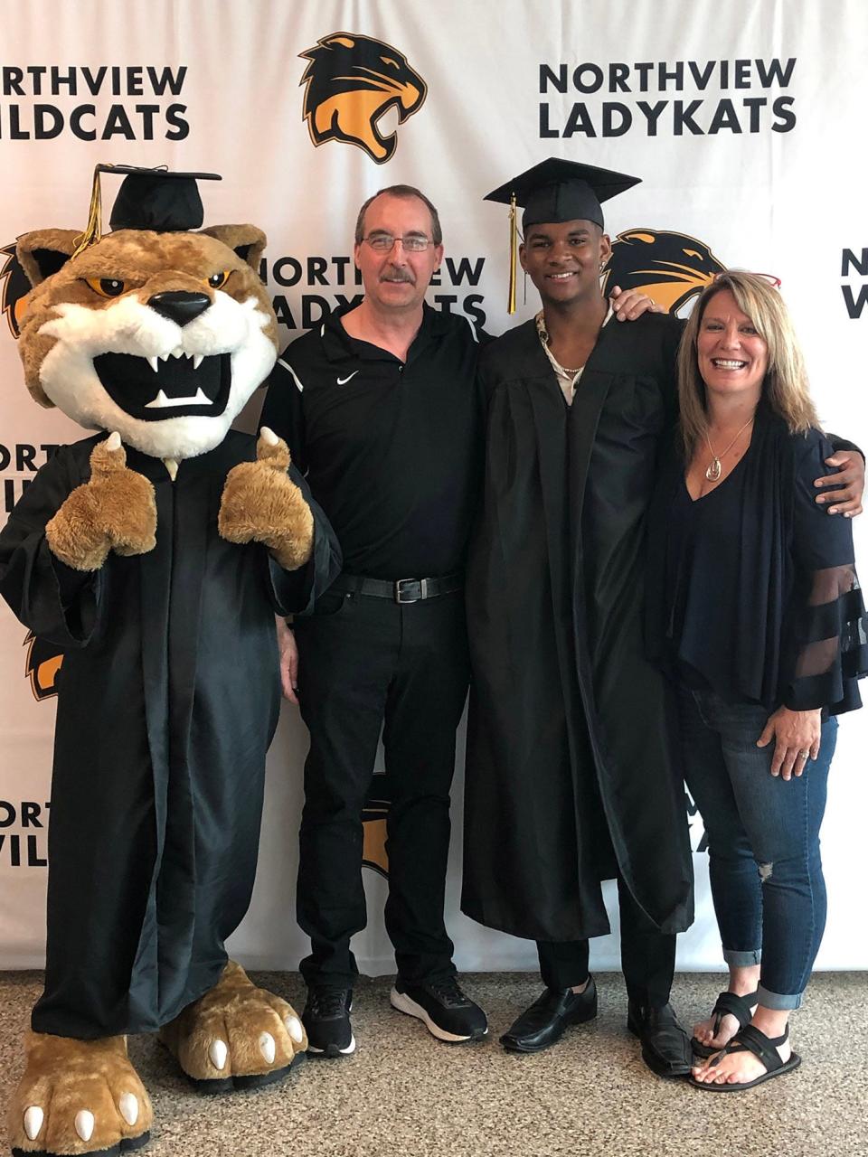 Isaiah Meyer-Crothers, middle, stands with his parents, Joni and Jamie, at graduation. Photo by Meyer-Crothers family