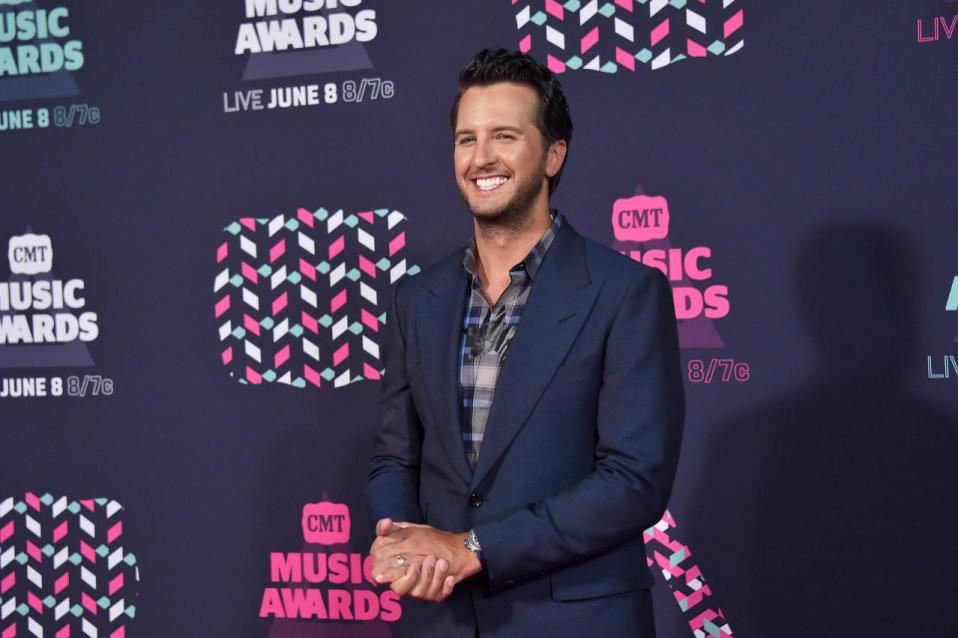 Luke Bryan looking ridiculously happy in a plaid shirt and blue blazer 