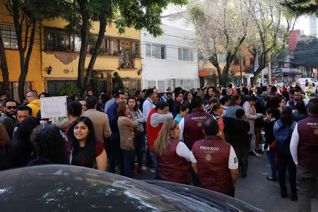 Office workers are seen at a street following an earthquake in Mexico City, Mexico February 1, 2019. REUTERS/Carlos Jasso