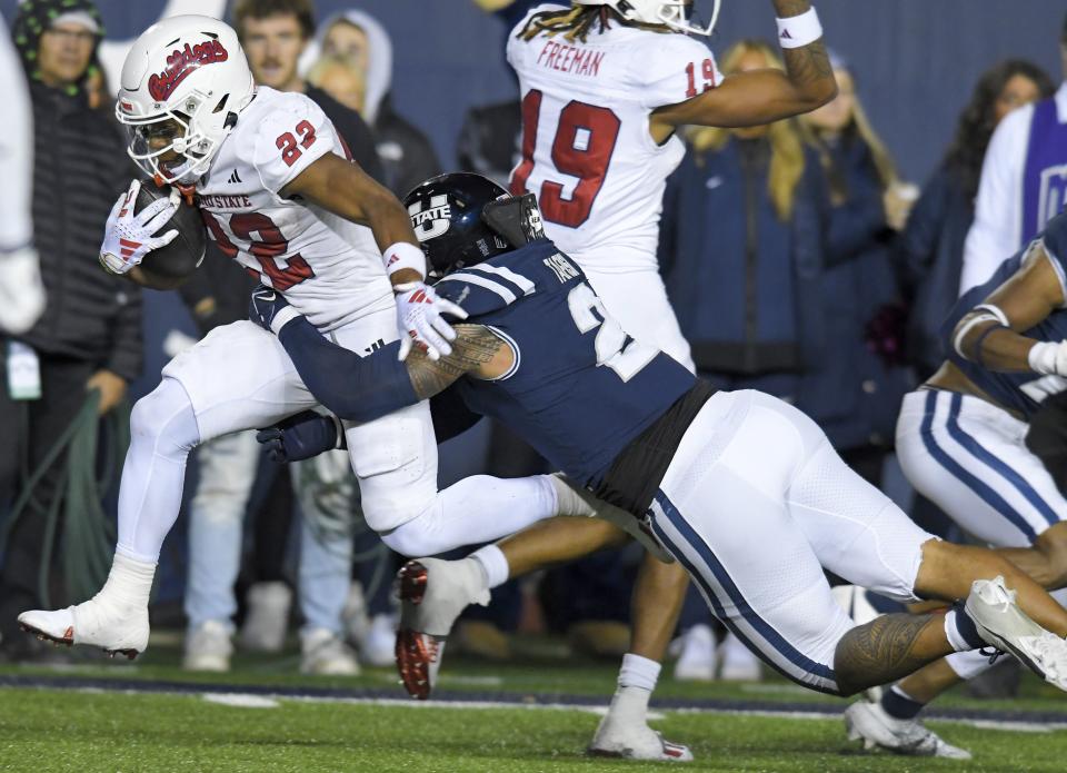 Fresno State running back Malik Sherrod (22) breaks an attempted tackle by Utah State linebacker MJ Tafisi Jr. (2) on the way to a touchdown during the second half of an NCAA college football game Friday, Oct. 13, 2023, in Logan, Utah. | Eli Lucero/The Herald Journal via AP