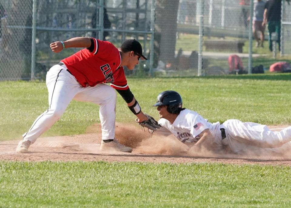 Onsted's Logan Hunt avoids a tag from Clinton's Kyle Wenk as he slides in safely at third during Tuesday's doubleheader.