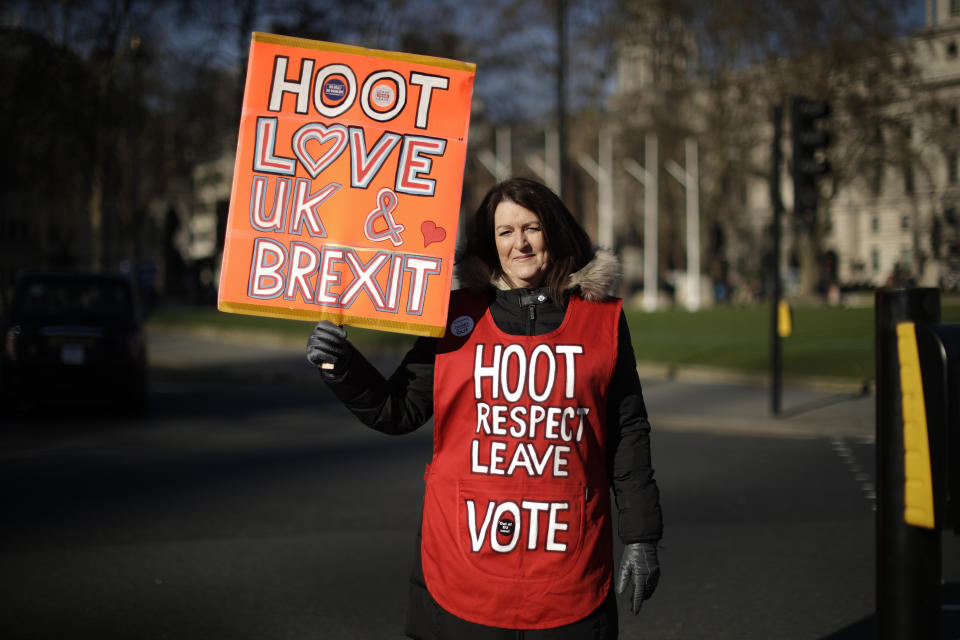 Leave the European Union supporter Michelle Megan from Newbury and originally from Dublin, Ireland, poses for photographs opposite the Houses of Parliament in London, Thursday, Feb. 14, 2019. Michelle believes leaving the EU properly, not with British Prime Minister Theresa's May deal would the best way forward. She would also like Ireland to "Irexit" from the European Union. With Brexit only days away, it is in the grounds outside parliament that the true believers gather each day to try to influence lawmakers, call attention to their cause, and bring new supporters into the fold.(AP Photo/Matt Dunham)