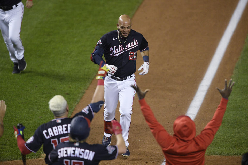Washington Nationals' Yadiel Hernandez, top, is welcomed after his game-ending, two-run home run during the eighth inning of the second baseball game of the team's doubleheader against the Philadelphia Phillies, Tuesday, Sept. 22, 2020, in Washington. The Nationals won 8-7. (AP Photo/Nick Wass)