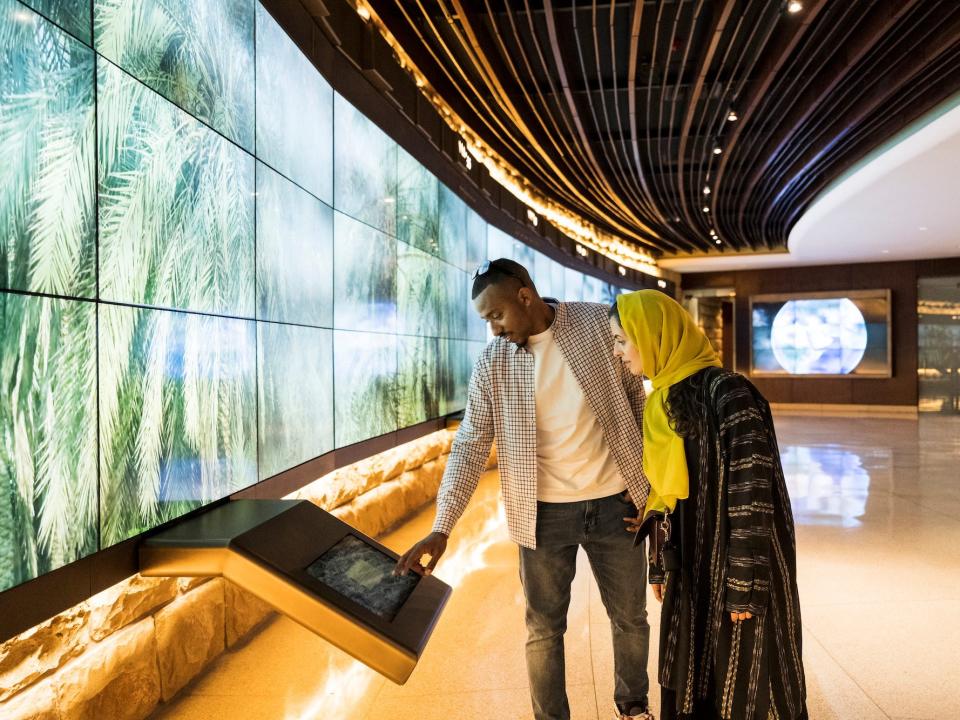A man and a woman look at a display in a museum.